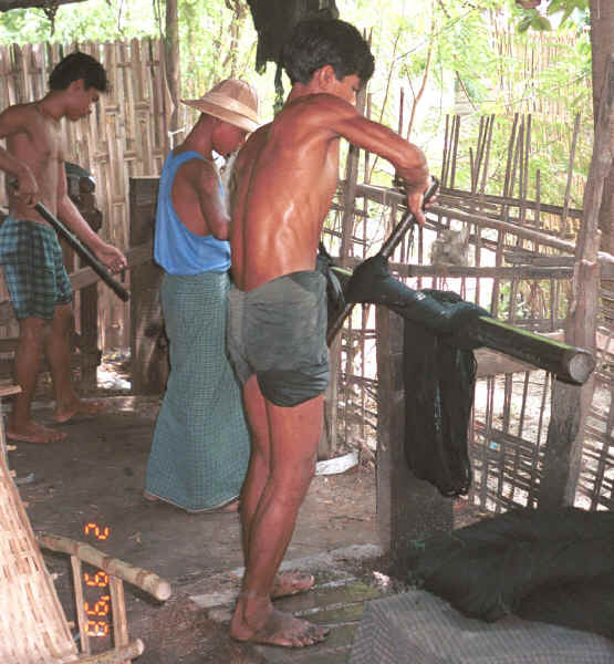 Straightening the threads and wringing out the water from the dyed cotton thread after it has been rinsed to stiffen and separate the threads - Amarapura, Shan State 9809e36.jpg