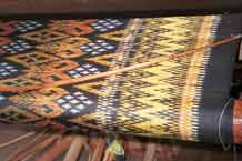 to Jpeg 52 K 9809P08A Four colour silk ikat on the loom at a weaving mill at Innbawkon (Inpawkhon) on Lake Inle, Shan State. Note the 'bow' across the width of the weft to keep the width and tension constant.