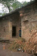 Jpeg 37K Pigeons on the slate roof of a stone house with their basket cotes below and the lady of the house near the door - Chang Tion village, Cheng Guan township, Puding county, Guizhou province 0010v35.jpg