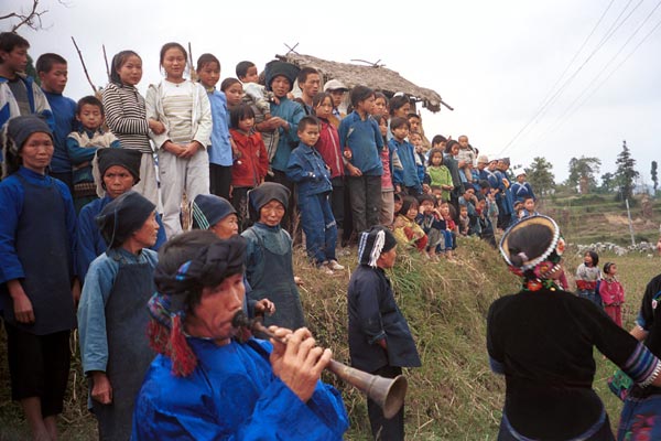 Jpeg 54K  0110D26 A trumpet being blown as part of our welcome to Gan He village, Ya Rong township, Huishui county, Guizhou province, south-west China. The people living in this village are known as Qing Miao.