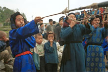 to Jpeg 58K  0110D30 Trumpeters blowing their welcome at Gan He village, Ya Rong township, Huishui county, Guizhou province, south-west China. Note the complex weaving of the ends of the head-cloths.These long trumpets are very loud! The people living in this village are known as Qing Miao. 