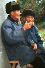 to Jpeg 56K  0110D32 Two old men watching our welcome to Gan He village, Ya Rong township, Huishui county, Guizhou province, south-west China. The people living in this village are known as Qing Miao.