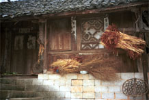 to Jpeg 57K 0110E18  The harvest drying outside a house in Gan He village, Ya Rong township, Huishui county, Guizhou province. This is a Qing Miao (or Bouyei/Miao as there has been much intermarriage and the costume is very mixed). 