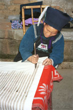 to Jpeg 48K 0110E21  A woman applying wax resist to cotton cloth in Gan He village, Ya Rong township, Huishui county, Guizhou province. This is a Qing Miao (or Bouyei/Miao as there has been much intermarriage and the costume is very mixed).