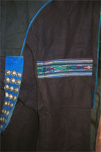 toJpeg 55K  0110E23  Part of a woman's indigo jacket showing an inserted band of weaving in the sleeve and silver buttons on the fastening in Gan He village, Ya Rong township, Huishui county, Guizhou province. This is a Qing Miao (or Bouyei/Miao as there has been much intermarriage and the costume is very mixed). 
