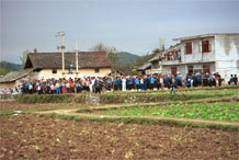 to Jpeg 57K  0110E25 Villagers gathered together for our visit in Gan He village, Ya Rong township, Huishui county, Guizhou province, south-west China. The people living in this village are known as Qing Miao. There has been much intermarriage between Miao and Bouyei which is evident from the costume of the women. 