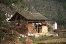 to Jpeg 49K  /0110E28 House and barn near Gan He village, Ya Rong township, Huishui county, Guizhou province. This is a Qing Miao (or Bouyei/Miao) village as there has been much intermarriage and the costume is very mixed). 