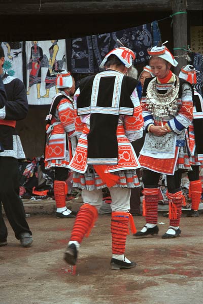 Jpge 54K 0111G06 Gejia dance troupe performing in Ma Tang village, Kaili City, Guizhou province in November 2001. The apparently wax resist fabric in their costume - at least the headdress, apron and sleeves of the blouse - are now made from commercially printed fabric which imitates the Gejia traditional wax resist designs.