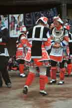 to Jpge 54K 0111G06 Gejia dance troupe performing in Ma Tang village, Kaili City, Guizhou province in November 2001. The apparently wax resist fabric in their costume - at least the headdress, apron and sleeves of the blouse - are now made from commercially printed fabric which imitates the Gejia traditional wax resist designs.