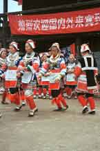 to Jpeg 62K 0111G13  Gejia dance troupe performing in Ma Tang village, Kaili City, Guizhou province in November 2001. The apparently wax resist fabric in their costume - at least the headdress, apron and sleeves of the blouse - are now generally made from commercially printed fabric which imitates the Gejia traditional wax resist designs.