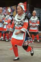 to Jpeg 52K 0111G18 Gejia dance troupe performing in Ma Tang village, Kaili City, Guizhou province in November 2001. The apparently wax resist fabric in their costume - at least the headdress, apron and sleeves of the blouse - are now generally made from commercially printed fabric which imitates the Gejia traditional wax resist designs