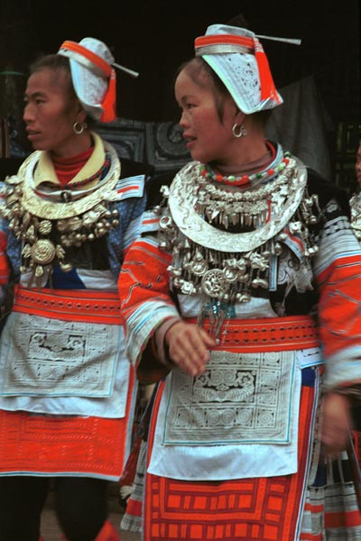 Jpeg 55K 0111G19 Gejia dance troupe performing in Ma Tang village, Kaili City, Guizhou province in November 2001. The apparently wax resist fabric in their costume - at least the headdress, apron and sleeves of the blouse - are now generally made from commercially printed fabric which imitates the Gejia traditional wax resist designs 