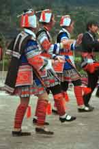 to Jpeg 56K 0111G20 Gejia dance troupe performing in Ma Tang village, Kaili City, Guizhou province in November 2001. The apparently wax resist fabric in their costume - at least the headdress, apron and sleeves of the blouse - are now generally made from commercially printed fabric which imitates the Gejia traditional wax resist designs 