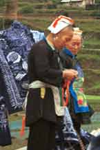 to Jpeg 60K 0111G21 Two Gejia women with their modern wax resist for sale to the tourists. Ma Tang village, Kaili City, Guizhou province.
