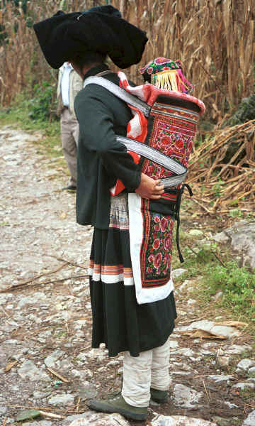 Side comb woman and baby wearing an embroidered hat and held in an embroidered baby carrier, Long Dong village, De Wo township, Longlin country, Guangxi province 0010d31.jpg