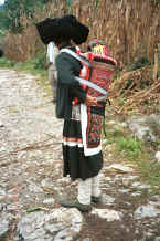 Jpeg 41K Side comb woman and baby wearing an embroidered hat and held in an embroidered baby carrier, Long Dong village, De Wo township, Longlin country, Guangxi province 0010d31.jpg