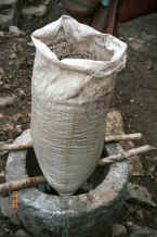Jpeg 33K Water seeping through a bag of potash into a stone vessel prior to mixing up the indigo dye vat, Side comb Miao, Long Dong village, De Wo township, Longlin country, Guangxi province 0010e19.jpg
