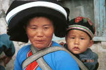 Jpeg 34K Side comb woman and child showing baby carrier straps of batik and boy wearing his embroidered cap - Long Dong village, De Wo township, Longlin country, Guangxi province 0010f10.jpg