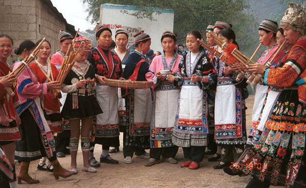 Jpeg 93K Miao women greeting us with alchohol, small carved charms and lusheng pipe music as we enter Lou Jia Zhuang village, Anshun city, Guizhou province. 0110A19