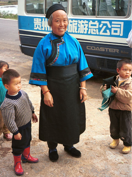 Jpeg 93K Lao Han woman with children who came to see what was happening at the Miao village. She felt that she was not looking smart enough in her apron so took it off to be photographed (see the small boy on the right of the photo holding the apron. Lou Jia Zhuang village, Anshun city, Guizhou province 0110A31 