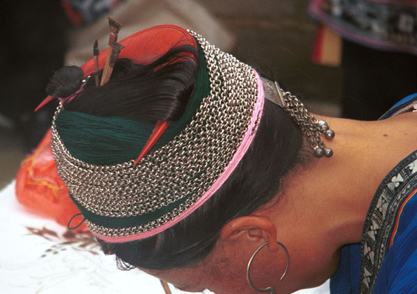 Jpeg 66K Miao woman concentrating on her wax resist. Note her traditional hair style (and three la dio (wax knives) tucked into her hair near the circular (red) comb. Lou Jia Zhuang village, Anshun city, Guizhou province 0110B20