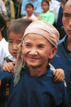 Jpeg 28K Old White Miao lady, probably with her grandson on her back and her son behind her in the crowd to welcome us to Ma Wo village, Zhe Lang township, Longlin county, Guangxi province 0010j03.jpg
