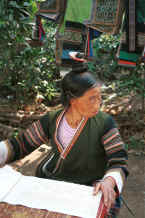 Jpeg 39K Side Comb Miao married woman about to start waxing a piece of batik.  Note her hairstyle which gives the group its Han nickname and how the continual twisting of the hair into a tight knot into which the comb is placed is causing some baldness. Pao Ma Cheng village, Teng Jiao township, Xingren country, Guizhou province. 0010n23.jpg