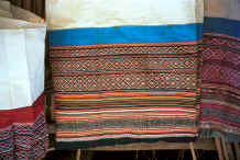 Jpeg 49K Side Comb Miao skirts hanging out to show the ornately embroidered tops - note that they are all embroidery and rather than batik - Pao Ma Cheng village, Teng Jiao township, Xingren country, Guizhou province 0010o13.jpg