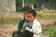 Jpeg 28K Young Miao boys at the entrance to the village against the stone houses and rice harvest - Sha Jiao village, Wan Teng township, Xingyi metropolitan area, Guizhou province 0010l09.jpg