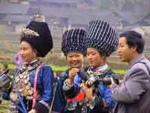 to Jpeg 46K Miao women dressed in their festival finery and examining cameras a village in Songtao Miao Autonomous County, Tongren Prefecture, eastern Guizhou Province.