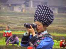 to Jpeg 37K Miao girl dressed in her festival finery testing the camera in a village in Songtao Miao Autonomous County, Tongren Prefecture, eastern Guizhou Province.