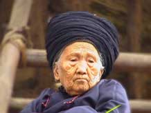 to Jpeg 37K An old woman, wearing her turban which may be between 6-10 metres in length, watching the festivities in a Miao village in Songtao Miao Autonomous County, Tongren Prefecture, eastern Guizhou Province.