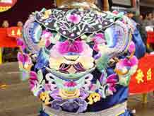 to Jpeg 54K Close up of the back view of a Miao girl at a festival in a village in Songtao Miao Autonomous County, Tongren Prefecture, eastern Guizhou Province. Note the bold embroidery collar covering the back of the blouse.