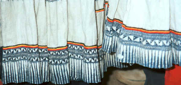 Close up of the batik and chain stitch embroidery decoration on the bottom of Big Flower Miao girls' skirts.  The fabric has been waxed on both sides with all the white areas covered in wax resist.  This has been very well done as the white is very pure and there is very little 'cracking' visible on the plain white hemp or ramie fabric.  Xian Ma village, Hou Chang township, Puding county, Guizhou province 0010x24.jpg