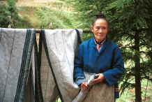 Jpeg 35K Li Jiang Ying, a Big Flower Miao woman who is 60 years old and had been taught at a missionary school, was the maker of both these two skirt lengths - the one on the left of the photo is made from ramie and the one on the right is hemp.  The indigo design on both has been created via a batik wax resist with the wax being applied to both sides of the fabric completely covering all the white areas of fabric. Xian Ma village, Hou Chang township, Puding county, Guizhou province 0010y12.jpg 0010y12.jpg