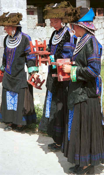 Young Black Miao girls dressed in their festival finery welcoming us by clapping small stools together. Zuo Qi village, Min Gu township, Zhenfeng county, Guizhou province 0010p16.jpg