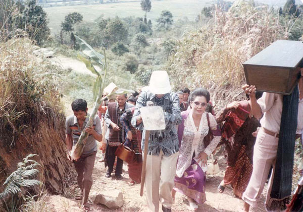 The Tobing family members accompanying the casket of Nai Horja's bones as they are carried up the hill for reburial. Various of her descendants take it in turn to carry the casket. Note how several are wearing traditional ulos.