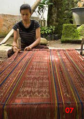 to 81K Jpg - setting up the warp on the loom: ikat dyed threads are set up with plain threads that will become warp patterned bands in the finished textile. Watublapi