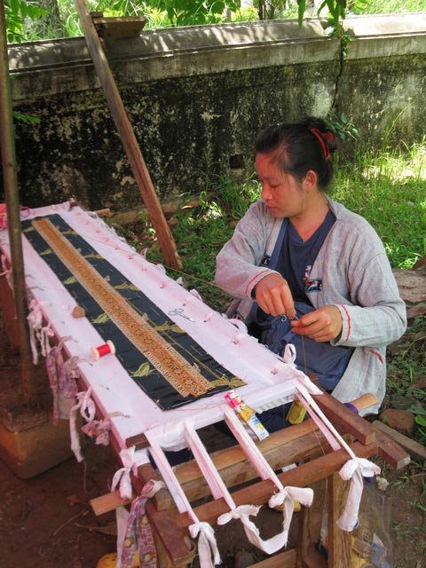 On the grounds of one of the wats In Luang Prabang, Laos, we bought cold drinks from a woman manning a small stall. Excitingly, she was couching golden threads on a small piece of cloth! It was nice to see people still doing this in a serene open atmosphere and not in a sweatshop. She didn’t speak any English so unfortunately I don’t know if this was an item to be sold later or for her own use. I did compensate her for taking photos!