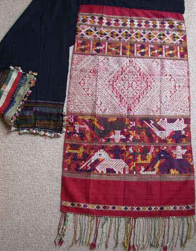 Jpeg 62K Silk supplementary weft end of a pha biang showing siho, mythological animals half-lion, half-elephant, unique to the Lao culture, with spirit figures on their backs walking amongst other figures including nak