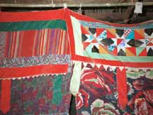 14. to Jpeg 46K Decorative headings to curtains separating sleeping from living areas in a Black Thai house. Note the woven fabric in the heading to the left and pieced work in the heading to the right. The hanging tabs echo those on some of the baby carriers in the area. Dien Bien Phu, Lai Chau Province October 1995.