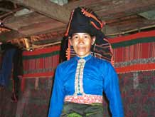 13. 54K Jpeg Black Thai woman stanging in front of curtain room dividers separating sleeping from living areas in a Black Thai (Tai Dam) house in Dien Bien Phu, Lai Chau province photographed in October 1995.