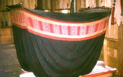 Jpeg 29K Tai Daeng poei cotton indigo mosquito net with red silk decorative band attached around the upper section, Xam Nuea style, Houa Phan province. The photo is Fig 9.31, page 219 in "Lao-Tai Textiles: The Textiles of Xam Nuea and Muang Phuan" by Patricia Cheesman and published by Studio Naenna Co in 2004.