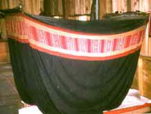 5. to Jpeg 29K Tai Daeng poei cotton indigo mosquito net with red silk decorative band attached around the upper section, Xam Nuea style, Houa Phan province. The photo is Fig 9.31, page 219 in "Lao-Tai Textiles: The Textiles of Xam Nuea and Muang Phuan" by Patricia Cheesman and published by Studio Naenna Co in 2004.