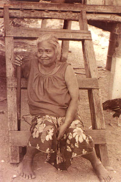 ss20 Jpeg 58K An elderly woman from the same village near Ranong. The houses in this village are built on stilts. These last two photos illustrate the wearing of the ubiquitous sarong with a loose cotton blouse, a uniform rapidly replacing ethnic costumes, thoughout Thailand