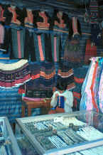 to Jpeg 39K Blue Hmong woman sewing applique in front of an array of clothing 8812l16A