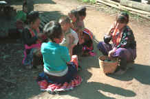 to Jpeg 33K Blue Hmong women and children chatting and sewing in a village along the road from Chiang Mai to Fang 7712n31