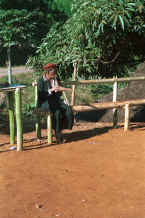 to Jpeg 38K U Lo-Akha man playing a musical gourd and bamboo pipes for young boys to sing a welcome at the entrance to a village in the hills around Chiang Rai 8812p12.jpg