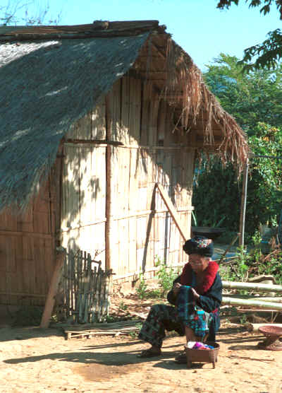 A Yao woman sitting in the sunshine outside a house working on her embroidery in a village in the hills around Chiang Rai 8812q08.jpg
