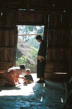 to Jpeg 26K A young Yao family framed in the doorway of their house in a village in the hills around Chiang Rai 8812q14.jpg